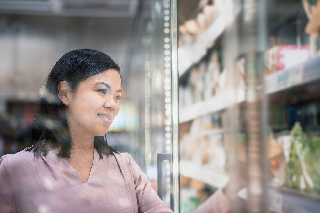 Junge Frau beim Einkaufen während des Aufblasens im Supermarkt