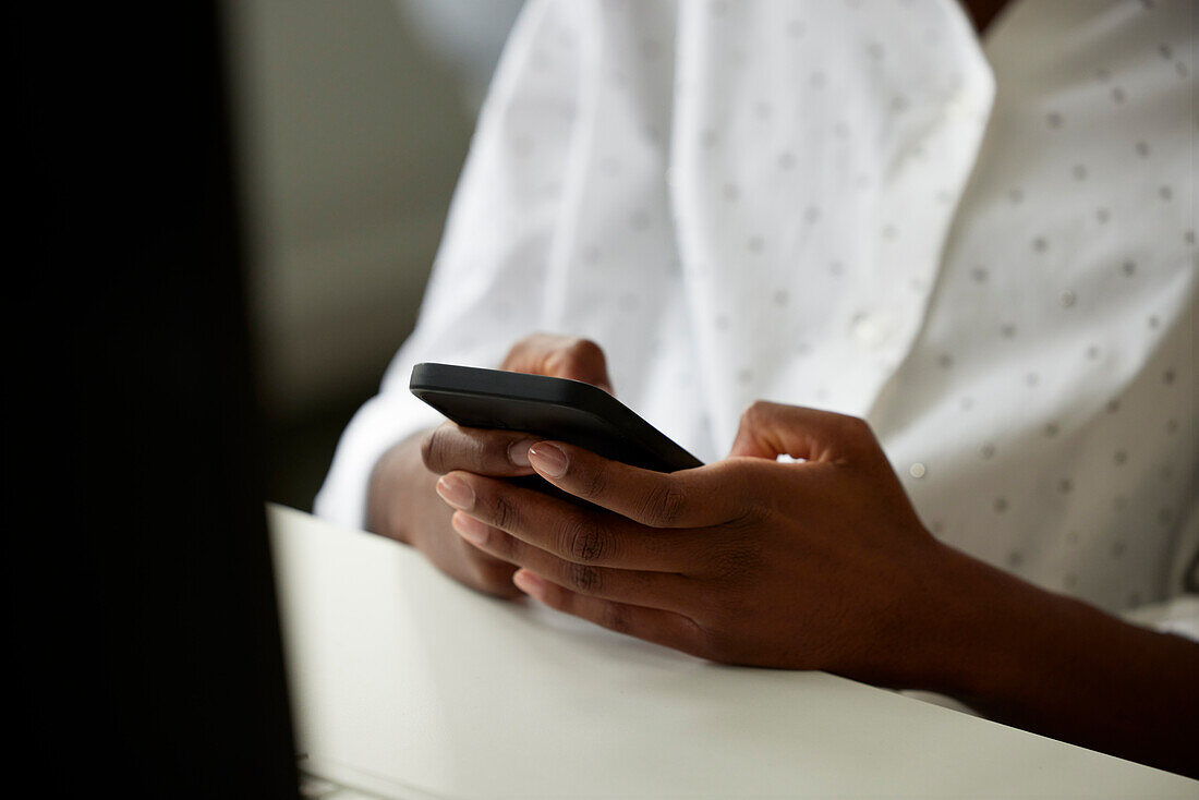 View of woman's hands using cell phone\n