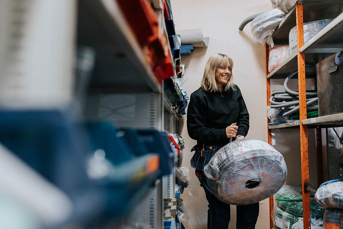 Female worker taking equipment from shelf\n