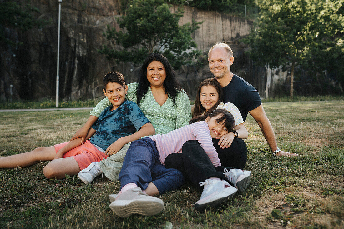 Porträt einer glücklichen Familie beim Entspannen im Park im Sommer