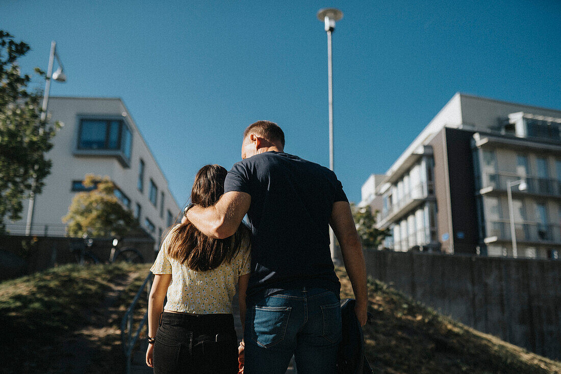 Vater und Tochter umarmen sich auf dem Heimweg