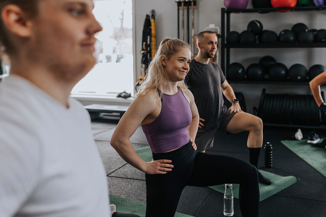 Smiling woman standing in gym during fitness class\n