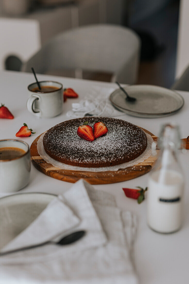 Freshly baked chocolate cake with strawberries on table\n