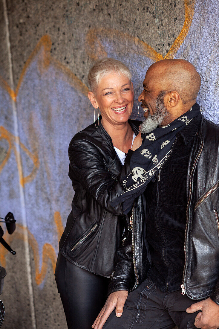 Affectionate mature biker couple in leather clothes\n