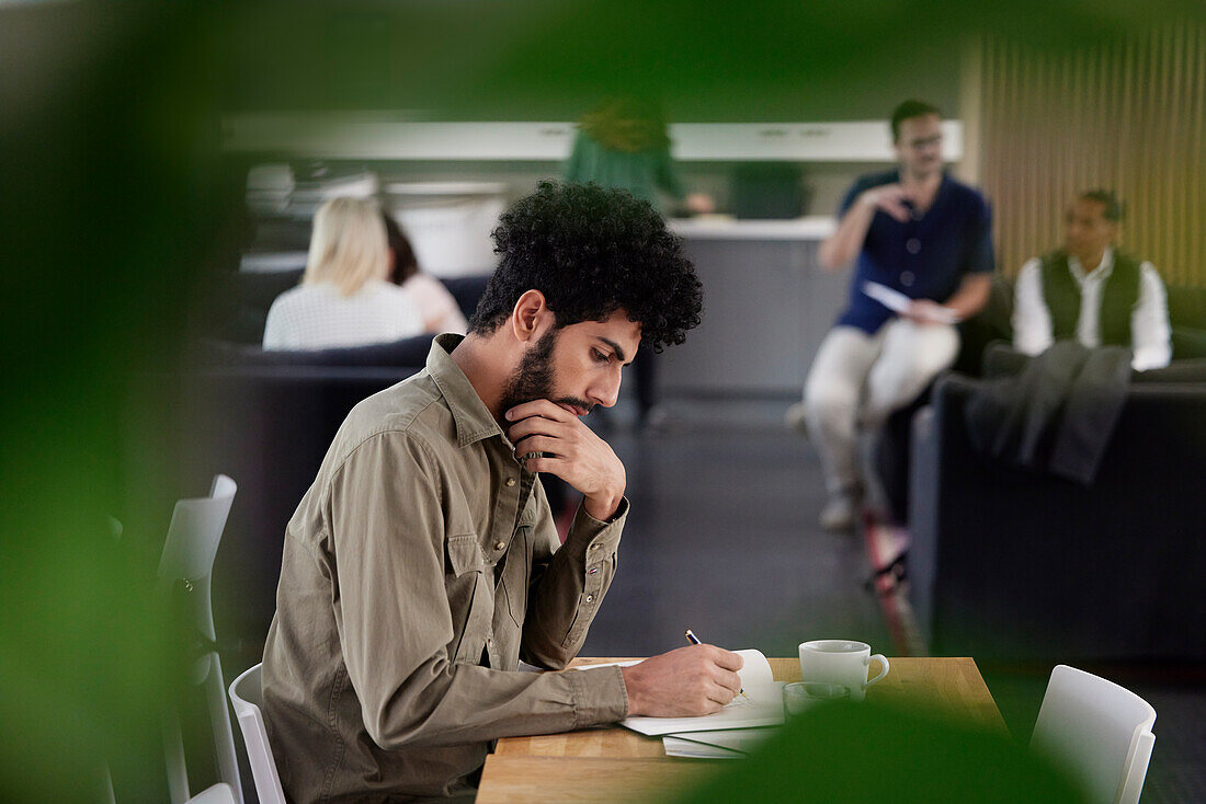 Mann arbeitet allein in Büro-Cafeteria