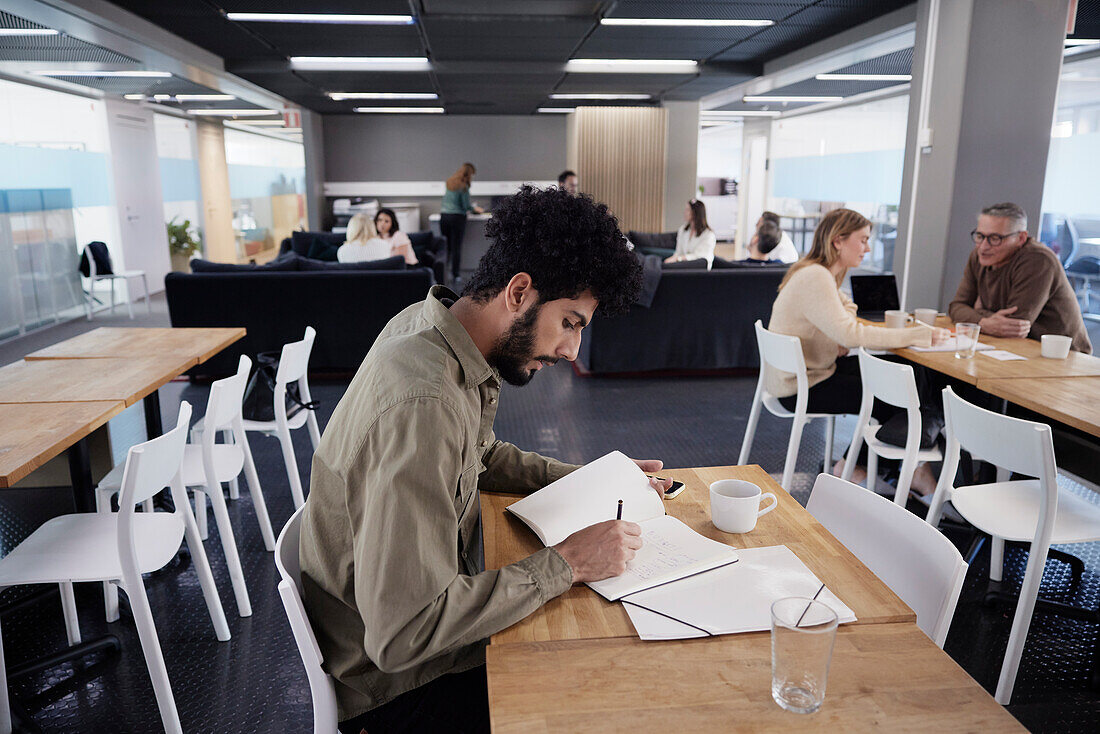 Man working solitary in office cafeteria\n