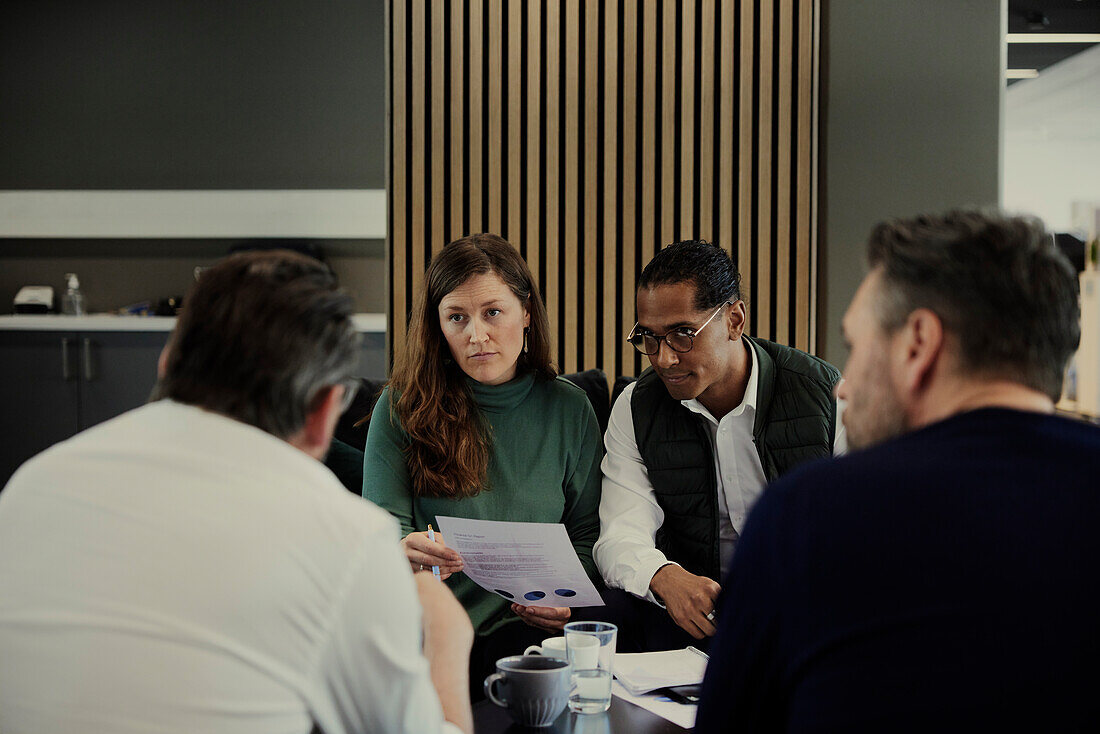 Group of business people having meeting in lobby\n