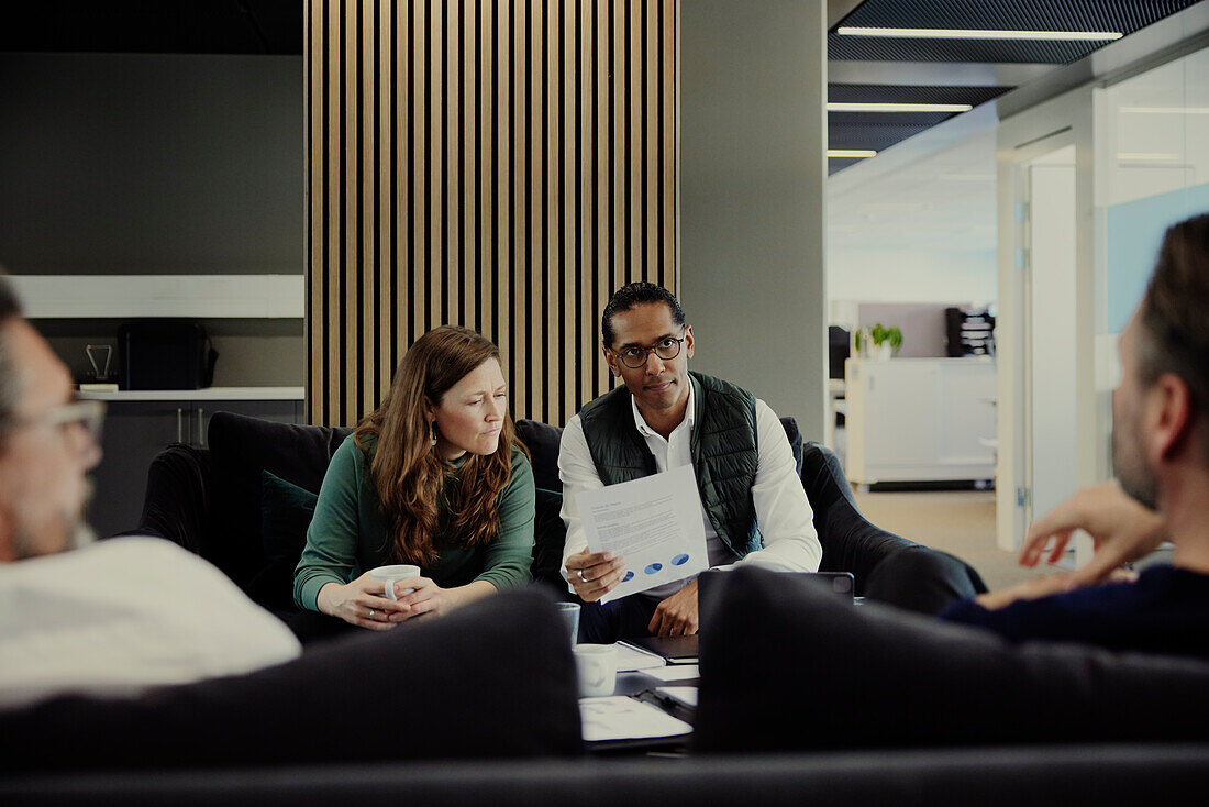 Group of business people having meeting in lobby\n