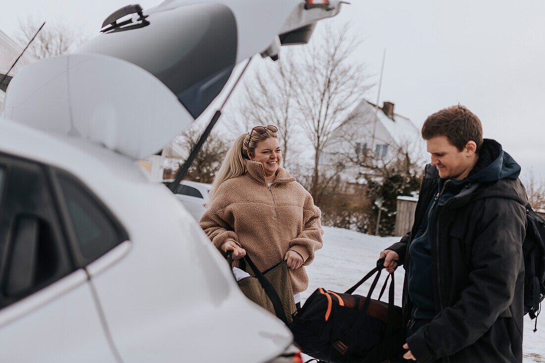 Menschen packen Tasche im Auto nach dem Training im Fitnessstudio