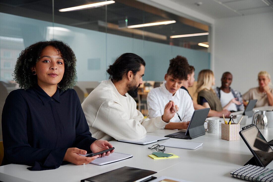 Woman sitting during business meeting and looking at camera\n