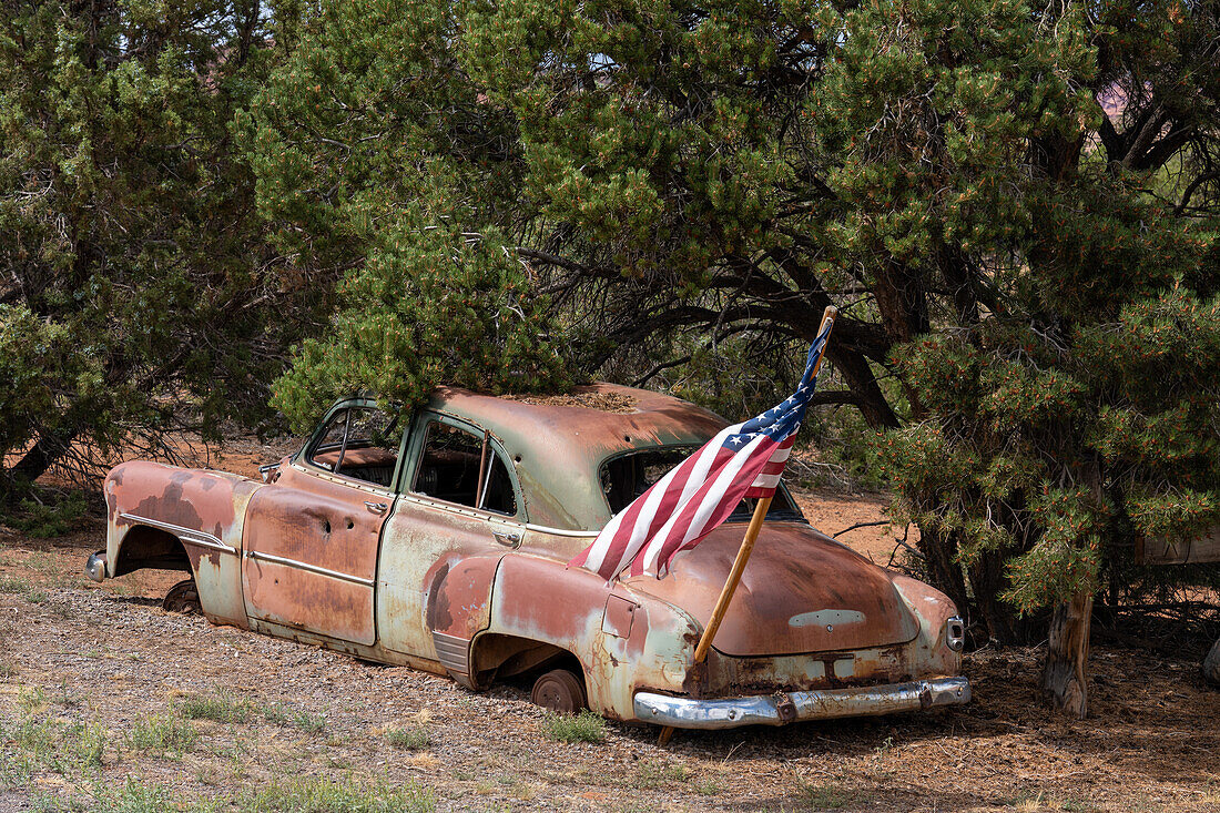 An American flag on an old junk 1950s car body near Torrey, Utah.\n