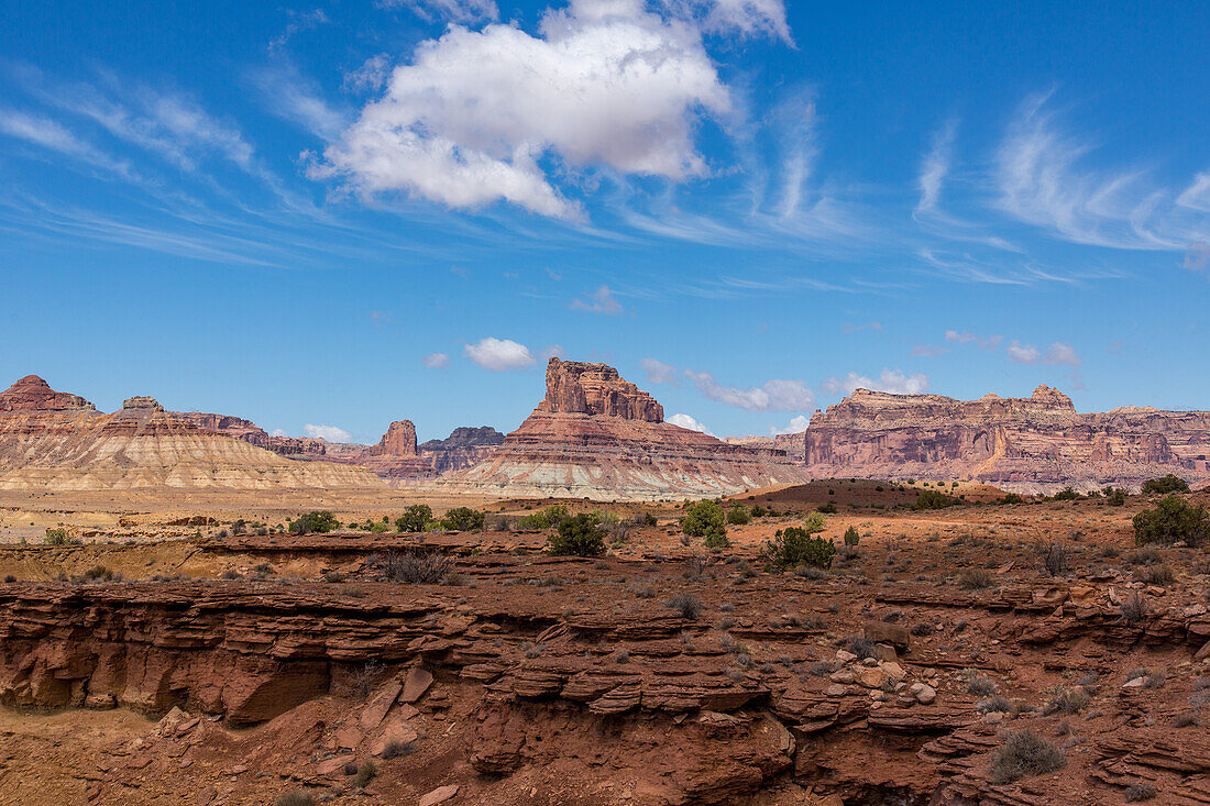 Assembly Hall Peak in the Mexican Mountain WSA on the San Rafael Swell in Utah. Overhead are both cumulus and high streaking cirrus clouds.\n