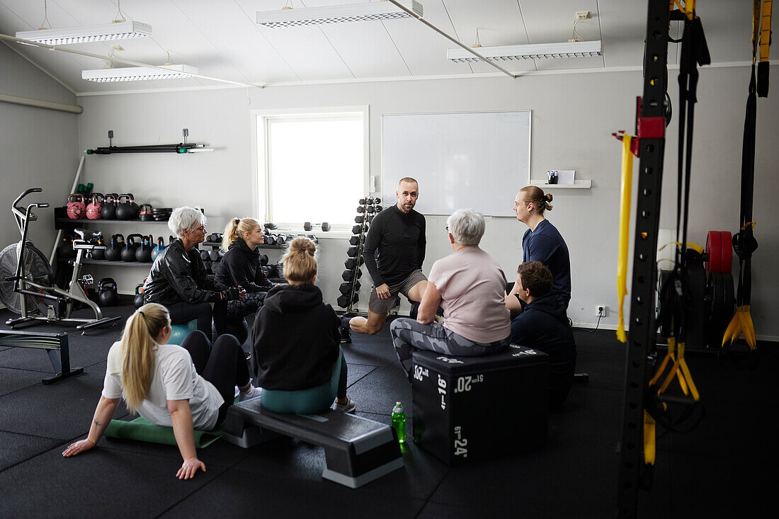 Smiling people exercising together in gym\n