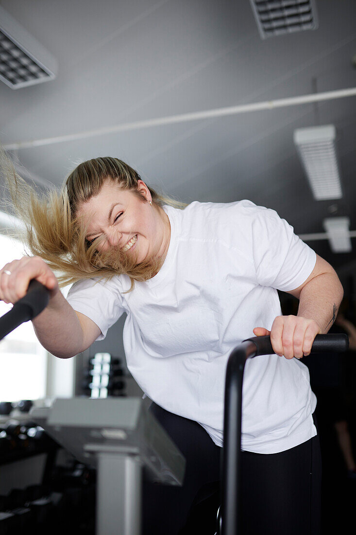 Blond woman exercising in gym\n