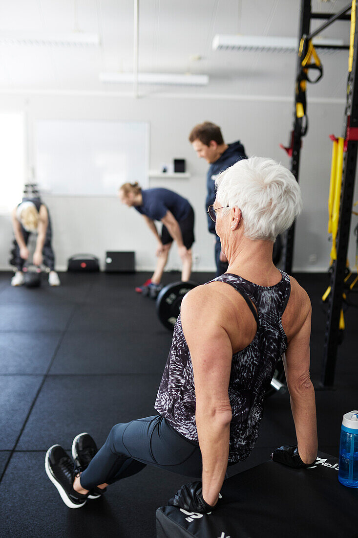 Senior woman exercising in gym\n