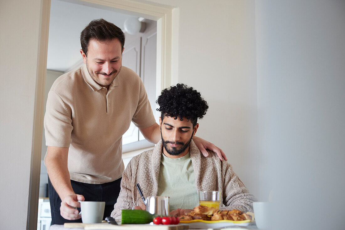 Glückliches schwules Paar beim Frühstück zu Hause