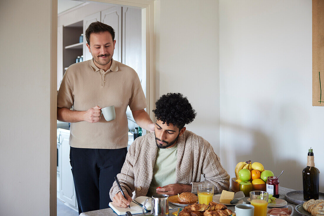 Glückliches schwules Paar frühstückt zu Hause