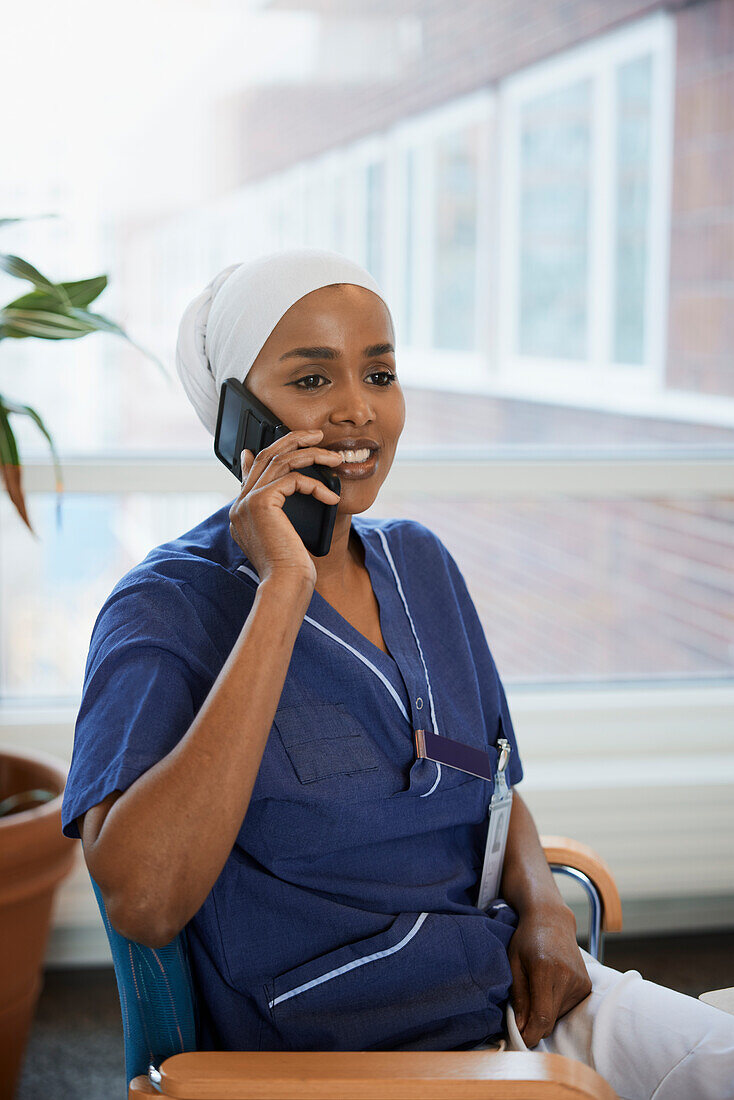 Young female doctor talking on phone at work\n