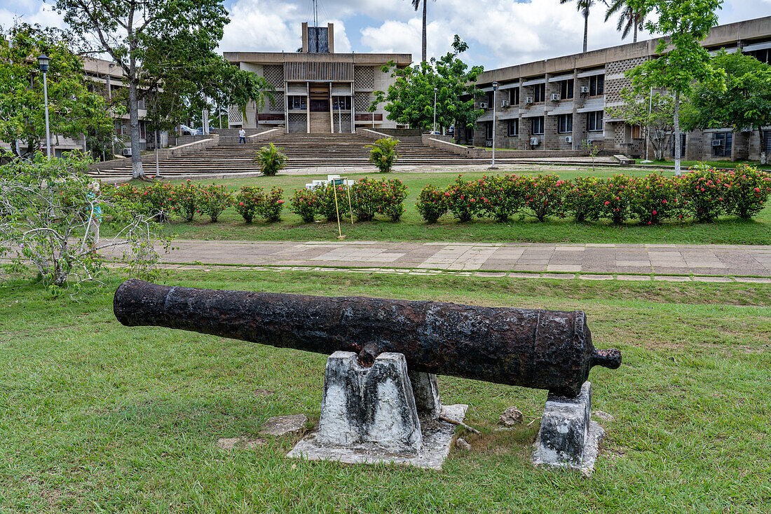 Eine Kanone aus der Kolonialzeit auf dem Independence Plaza in der Hauptstadt Belmopan, Belize. Dahinter befindet sich das Gebäude der Nationalversammlung.