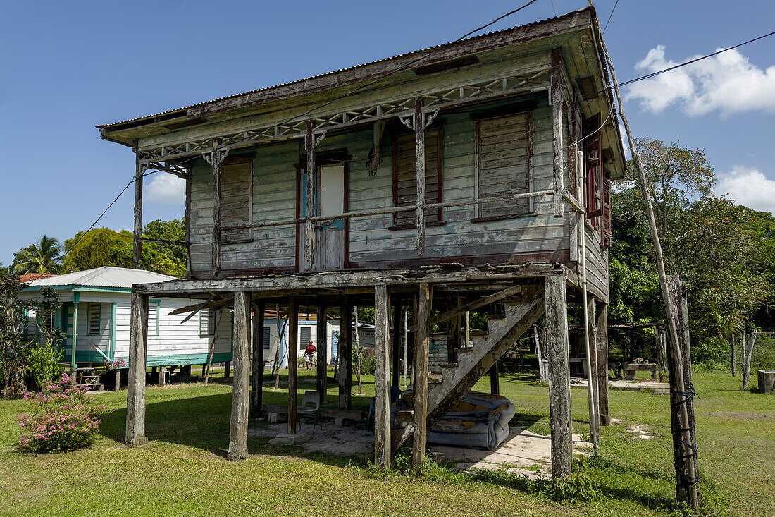 Ein verwittertes Schindelhaus im klassischen kreolischen Kolonialstil, typisch für die britische Kolonialzeit in Belize. Diese Häuser sind in der Regel vom Boden erhöht, um eine bessere Kühlung zu gewährleisten.