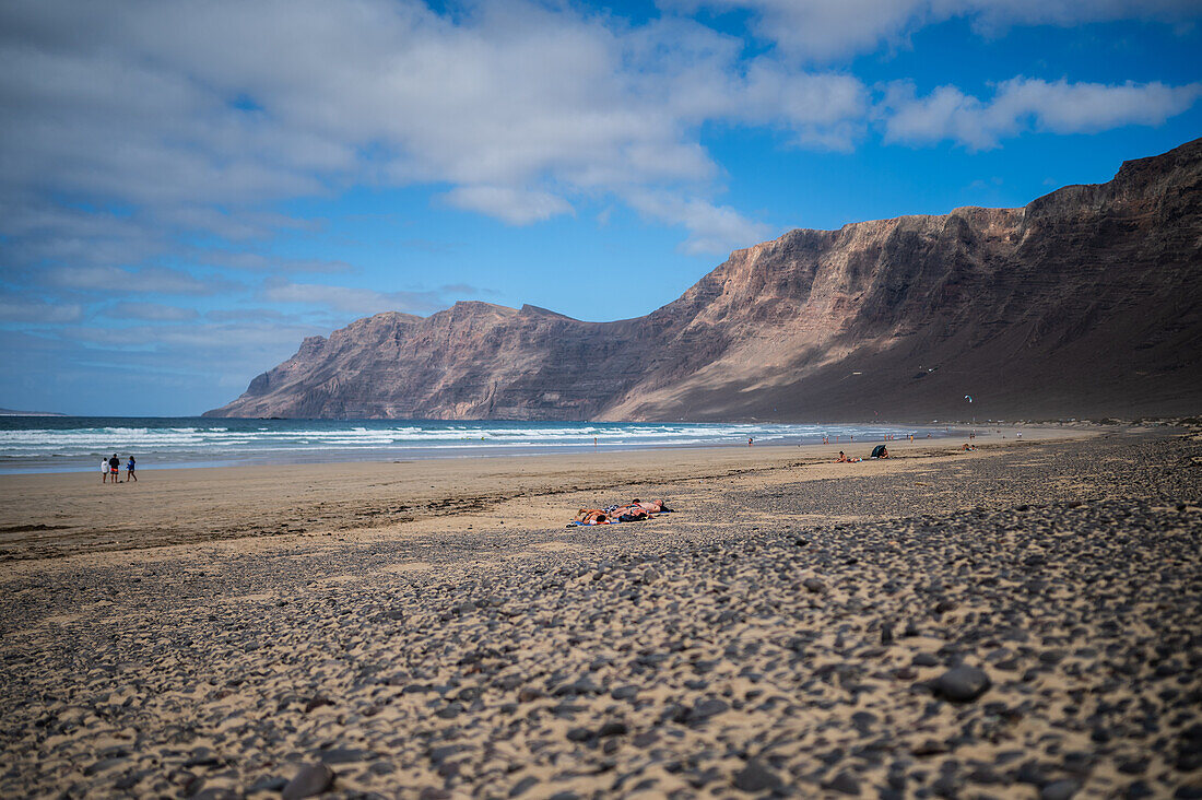 Famara beach (Playa de Famara), 6km golden sand beach located within the Natural Park of the Chinijo Archipelago, between the fishing village of La Caleta de Famara and the base of the impressive cliffs of Famara, Lanzarote, Canary Islands, Spain\n