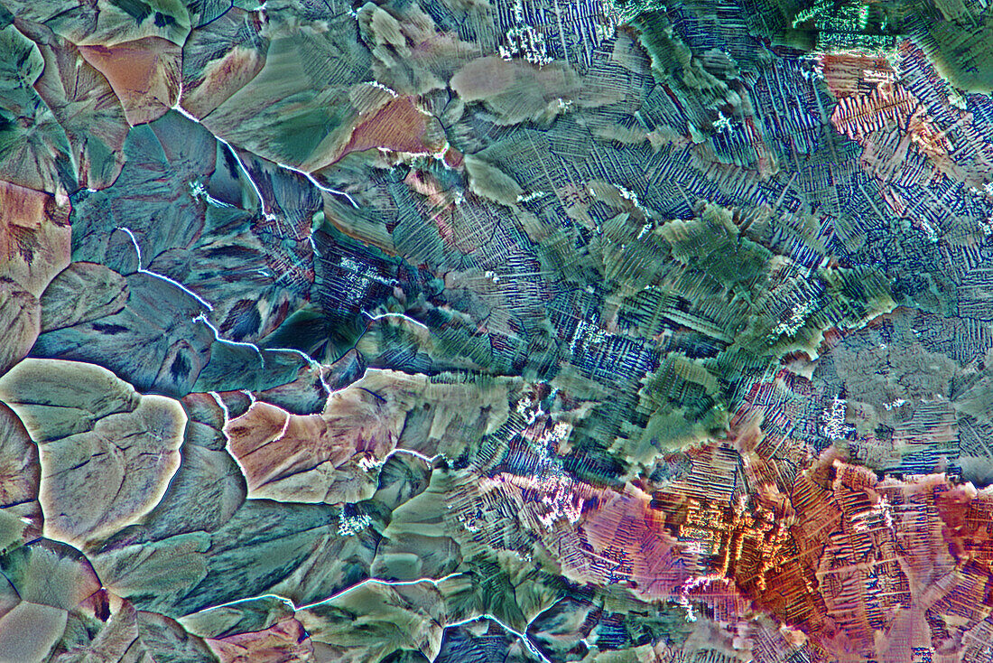 Das Bild zeigt ein kristallisiertes Gemisch aus Erythritol, Hydrochinon und TRIS, fotografiert durch das Mikroskop in polarisiertem Licht bei einer Vergrößerung von 100X