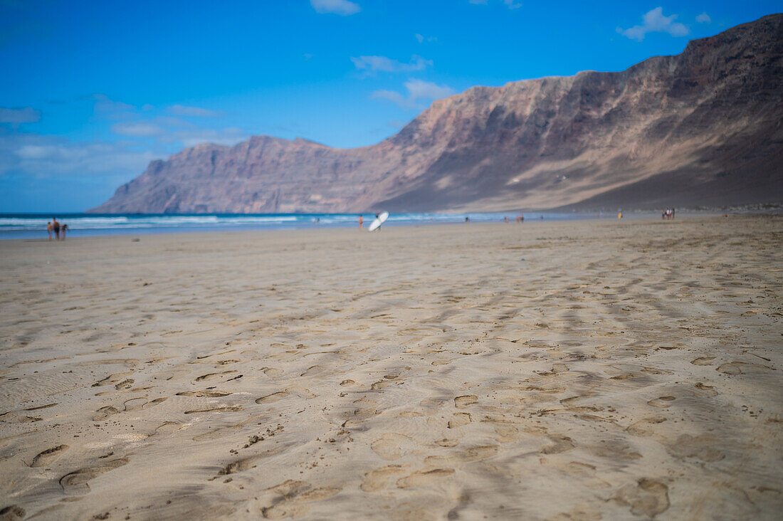 Strand von Famara (Playa de Famara), 6 km langer goldener Sandstrand im Naturpark des Chinijo-Archipels, zwischen dem Fischerdorf La Caleta de Famara und dem Fuß der beeindruckenden Klippen von Famara, Lanzarote, Kanarische Inseln, Spanien