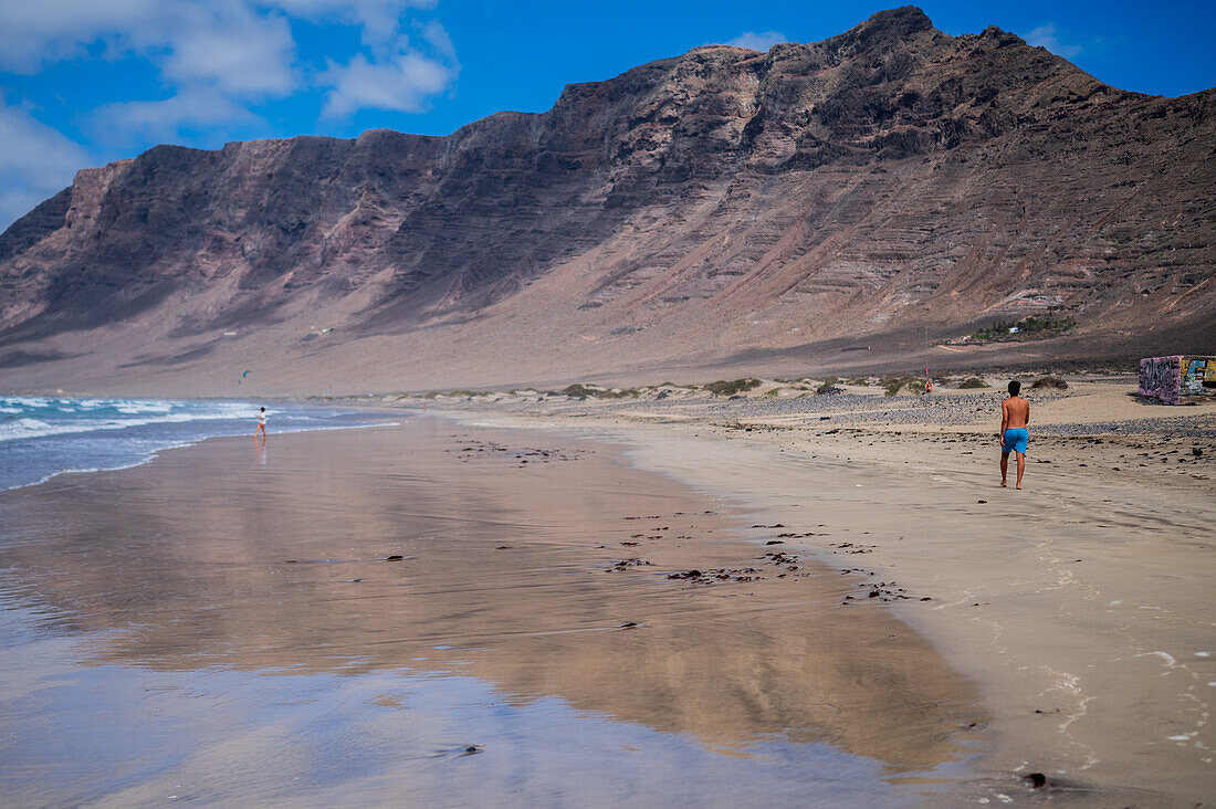 Der Strand von Famara (Playa de Famara), ein 6 km langer goldener Sandstrand im Naturpark des Chinijo-Archipels, zwischen dem Fischerdorf La Caleta de Famara und dem Fuß der beeindruckenden Klippen von Famara, Lanzarote, Kanarische Inseln, Spanien