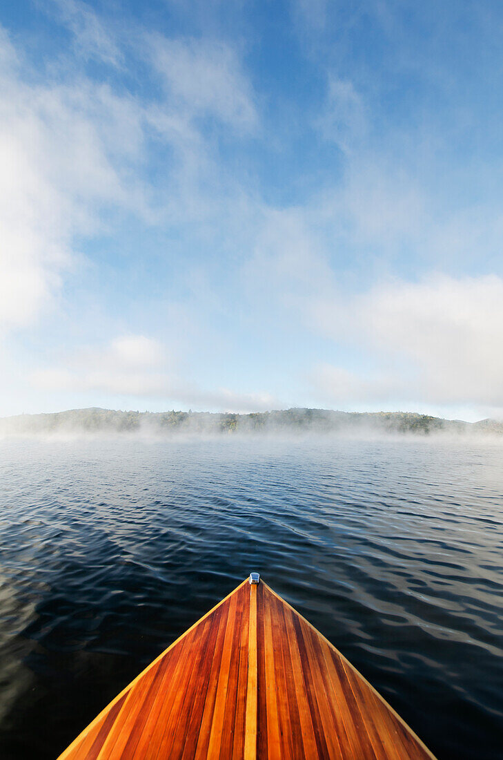 Boat on Lake Placid in morning mist\n