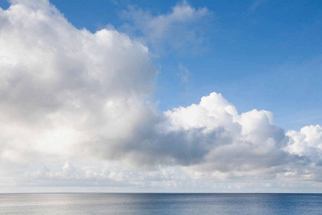 Weiße Schäfchenwolken über dem Meer