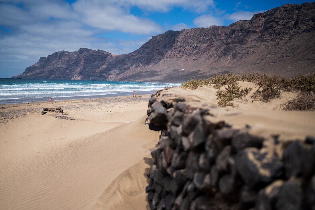 Strand von Famara (Playa de Famara), 6 km langer goldener Sandstrand innerhalb des Naturparks des Chinijo-Archipels, zwischen dem Fischerdorf La Caleta de Famara und dem Fuß der beeindruckenden Klippen von Famara, Lanzarote, Kanarische Inseln, Spanien