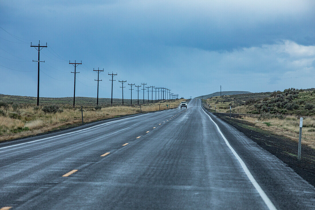 USA, Nevada, McDermitt, Electricity pylons along highway during stormy weather\n