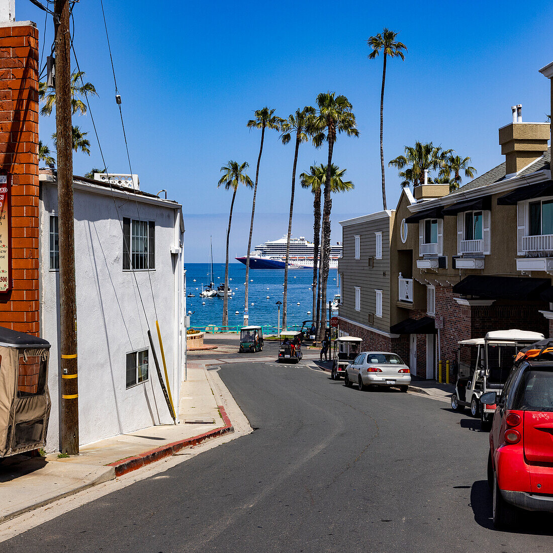 USA, California, Catalina Island, City of Avalon, View down street to Avalon Harbor where cruise ship is docked\n