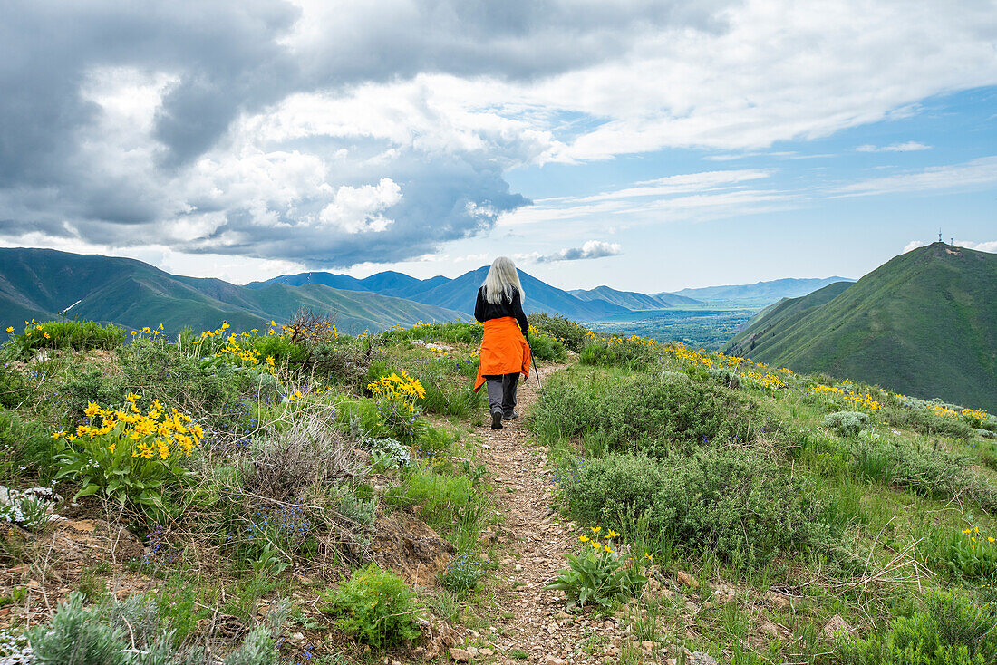 USA, Idaho, Hailey, Senior blonde woman hiking on Carbonate Mountain trail\n