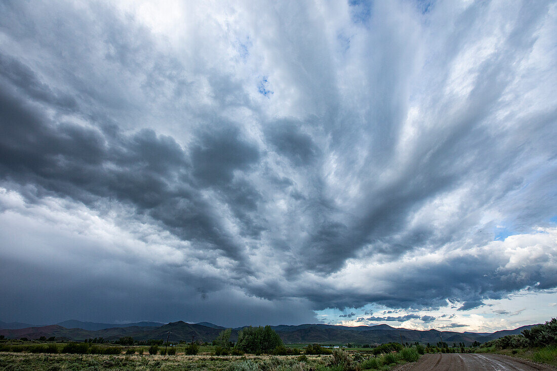 USA, Idaho, Bellevue, Storm clouds above landscape with meadow\n