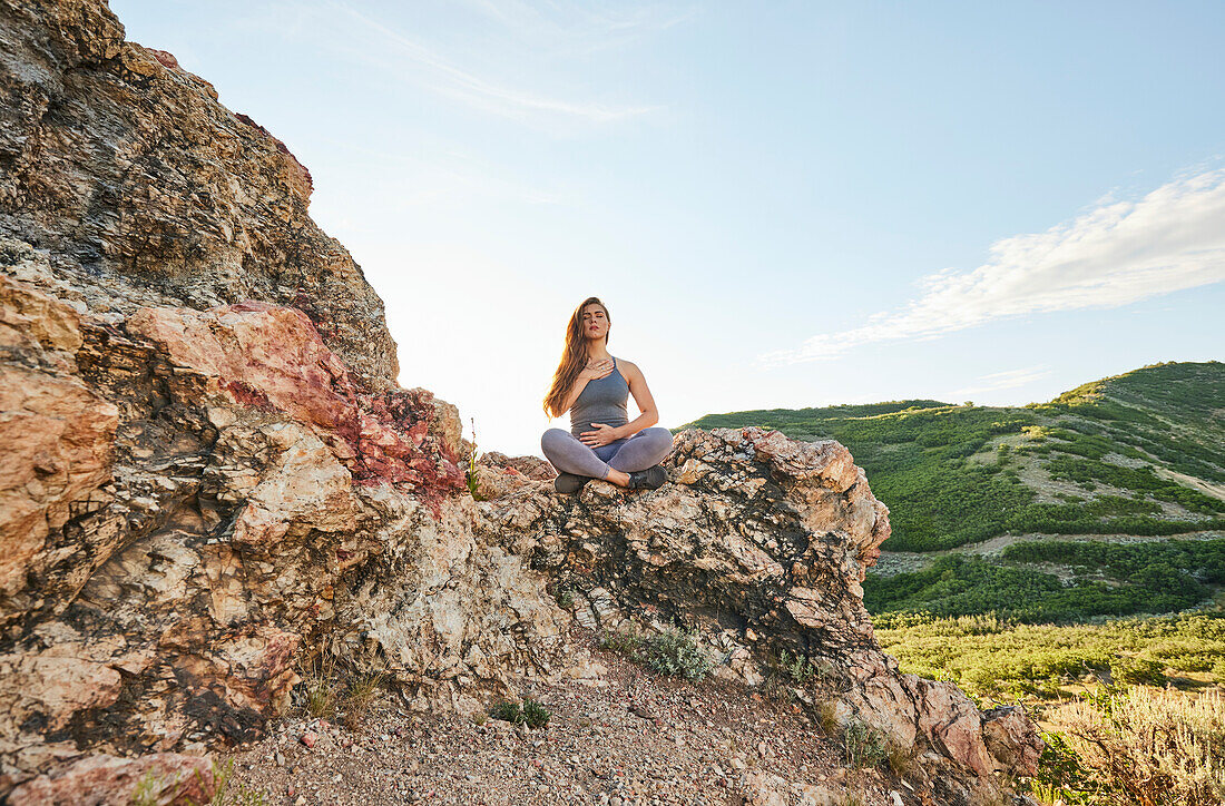 Mittlere erwachsene Frau meditiert in den Bergen