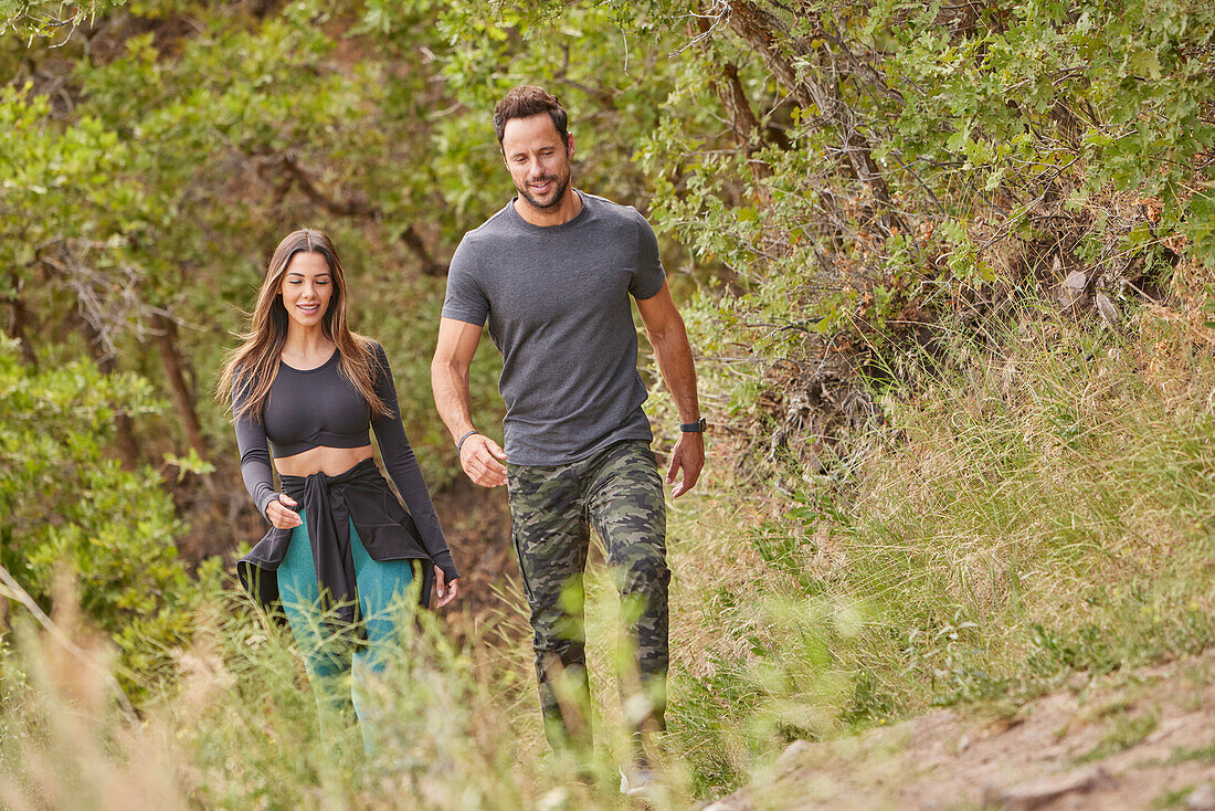 Mid adult couple hiking in forest\n