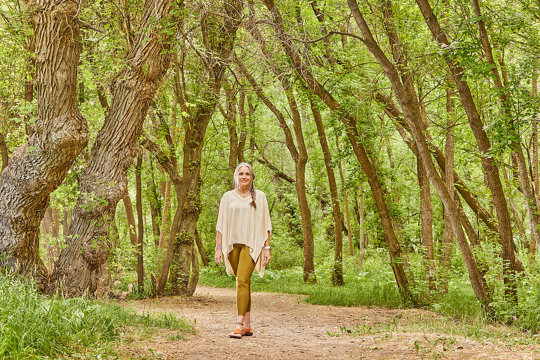 Smiling mature woman walking in park\n