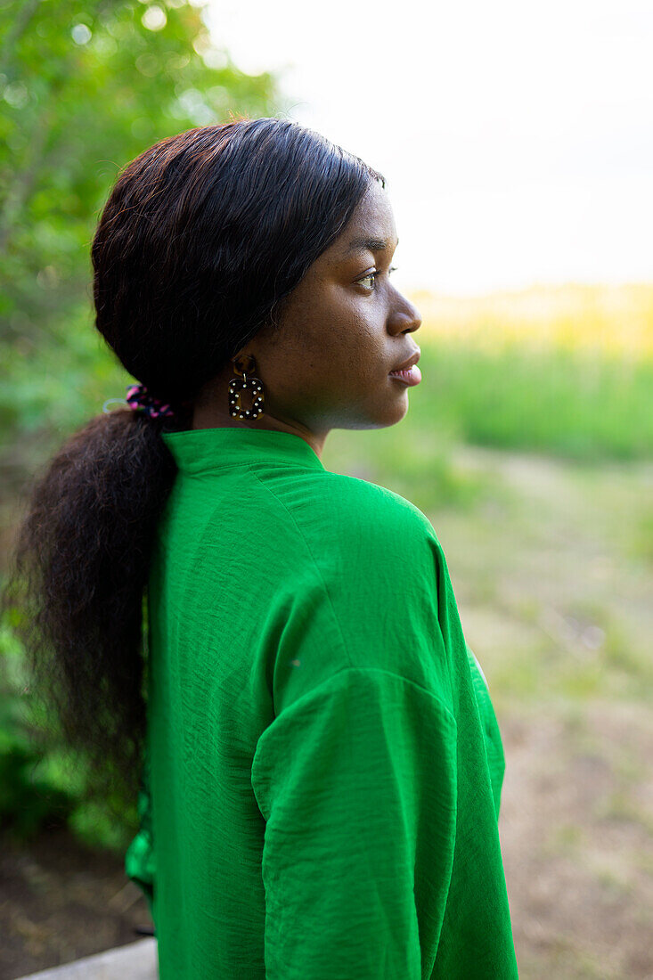 Seitenansicht einer brünetten Frau mit grüner Bluse