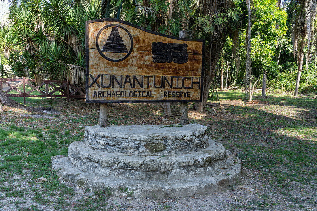 A carved wooden sign at the entrance of the Xunantunich Archeological Reserve in Belize.\n