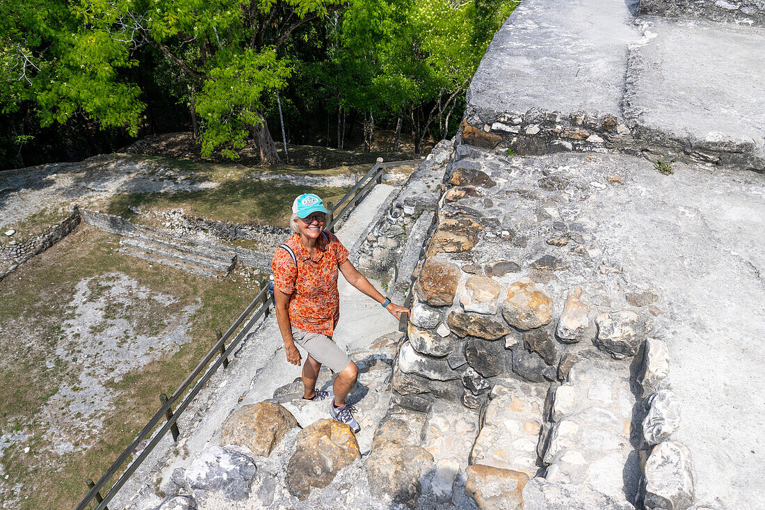 A tourist climbs the steep stairs on the rear of El Castillo, Structure A-6, in the Xunantunich Archeological Reserve in Belize.\n