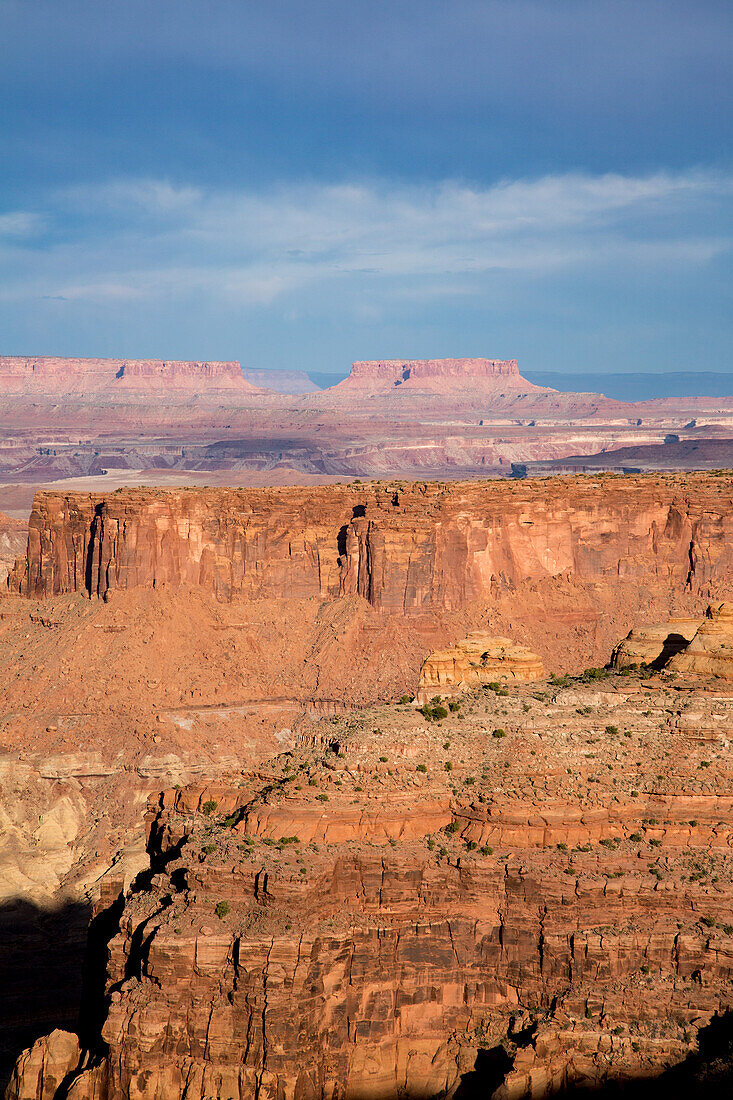 Sandstone formations along Millard Canyon in the Orange Cliffs of Glen Canyon NRA with Junction Butte in Canyonlands NP behind. Utah.\n