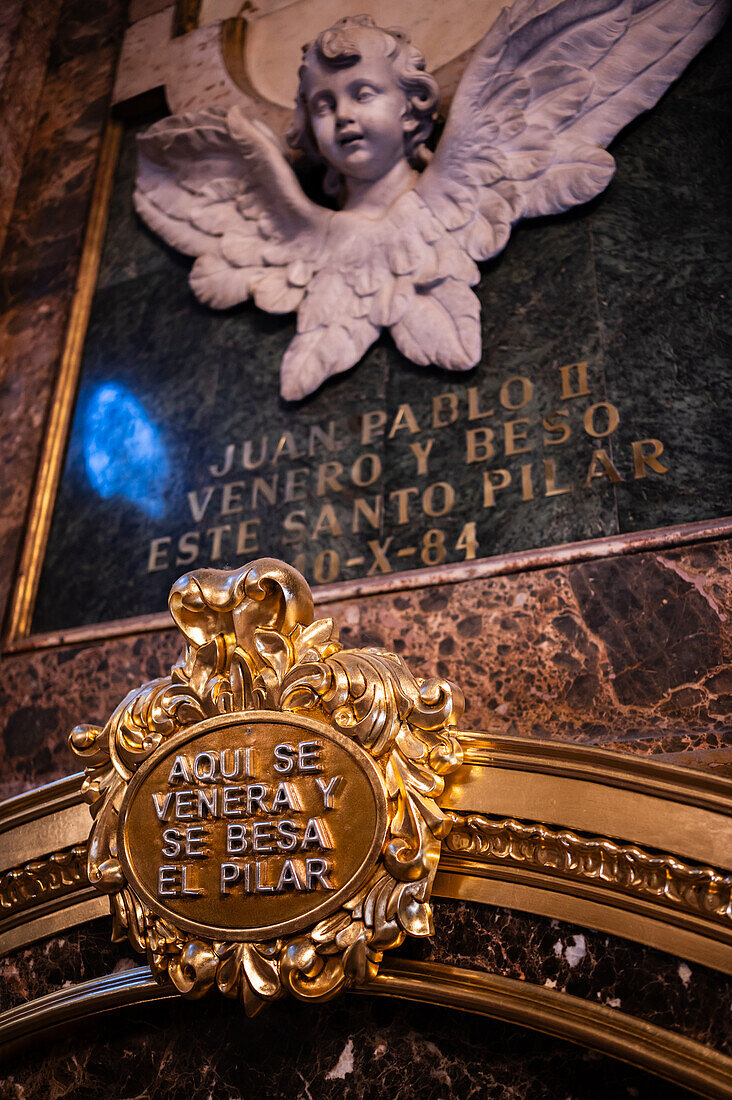 Worshipers kissing the pillar inside the Cathedral-Basilica of Our Lady of the Pillar during The Offering of Flowers to the Virgen del Pilar, the most important and popular event of the Fiestas del Pilar held on Hispanic Day, Zaragoza, Spain\n