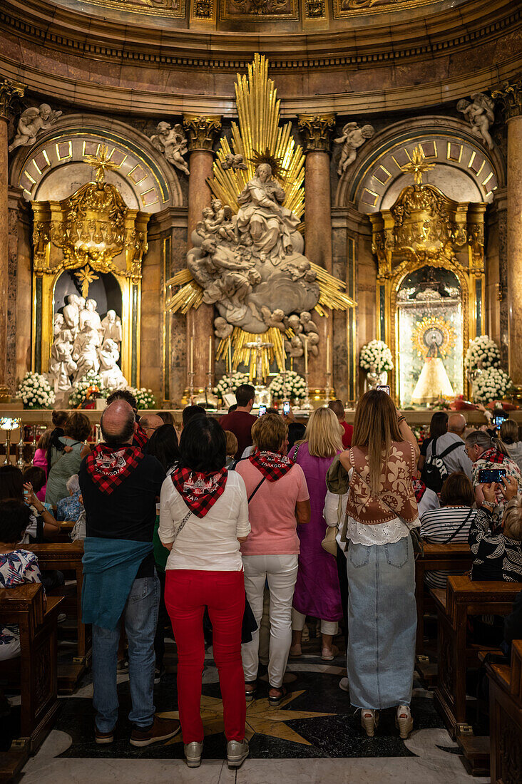 Gläubige in der Kathedrale-Basilika Unserer Lieben Frau von der Säule während der Blumenabgabe an die Virgen del Pilar, der wichtigsten und beliebtesten Veranstaltung der Fiestas del Pilar am Tag der Spanier, Zaragoza, Spanien