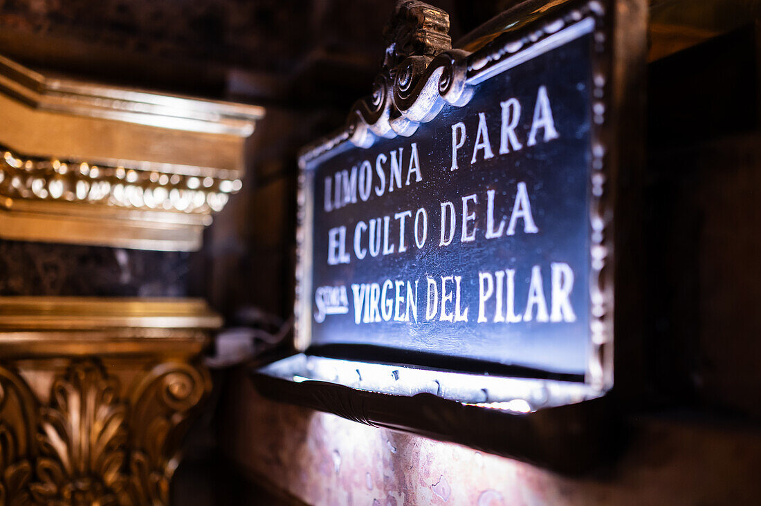 Verehrer küssen die Säule in der Kathedrale-Basilika Unserer Lieben Frau von der Säule während des Blumenopfers für die Virgen del Pilar, der wichtigsten und beliebtesten Veranstaltung der Fiestas del Pilar, die am Tag der Spanier stattfindet, Zaragoza, Spanien