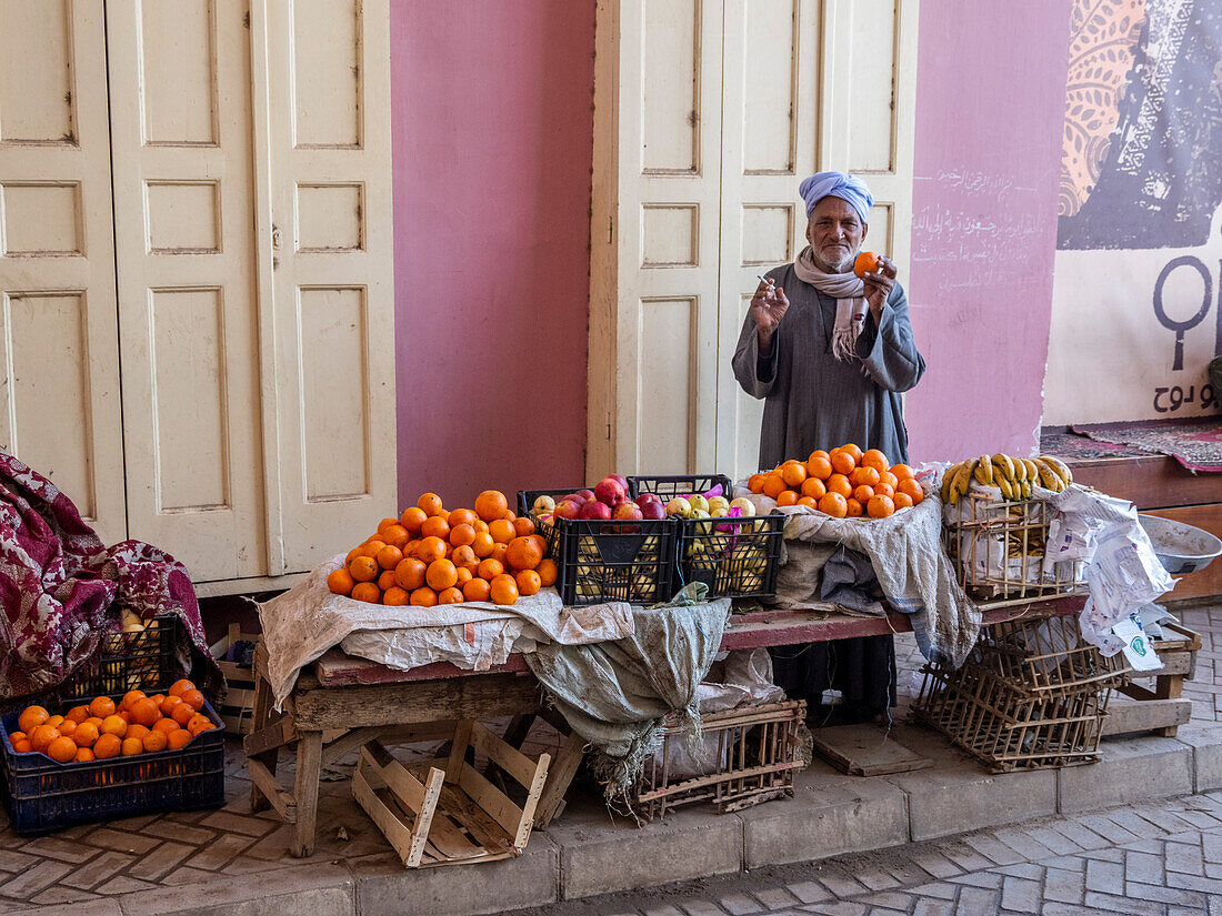 An old Egyptian vendor with his wares in the heart of the city of Dendera, Egypt, North Africa, Africa\n