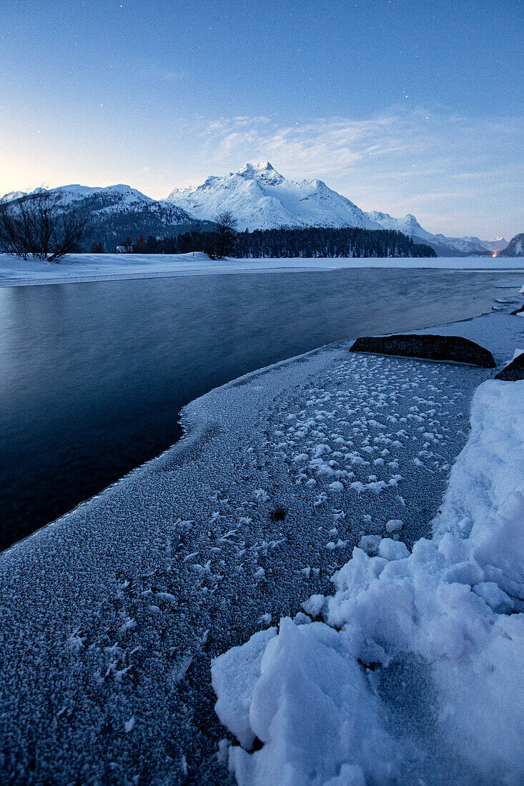 Winterlicher Sonnenaufgang über der gefrorenen Oberfläche des Silsersees im Winter, Engadin, Kanton Graubünden, Schweiz, Europa