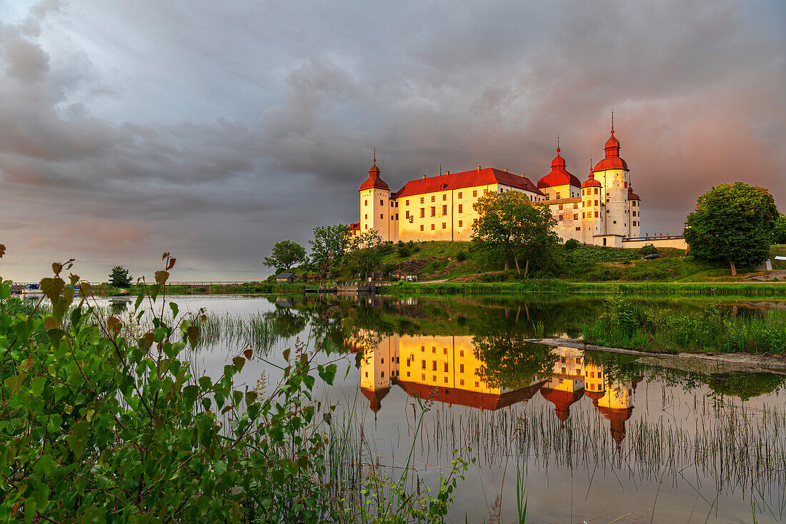 Lacko Castle and the reflection in the water at sunset, Kallandso island, Vanern lake, Vastra Gotaland, Sweden, Scandinavia, Europe\n