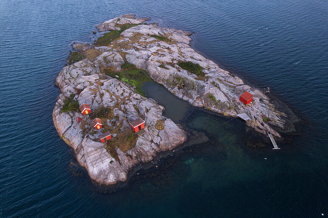 Rote traditionelle Bootshäuser und Hütten auf einer felsigen Insel, umgeben vom Meer, Bohuslan, Westschweden, Skandinavien, Europa