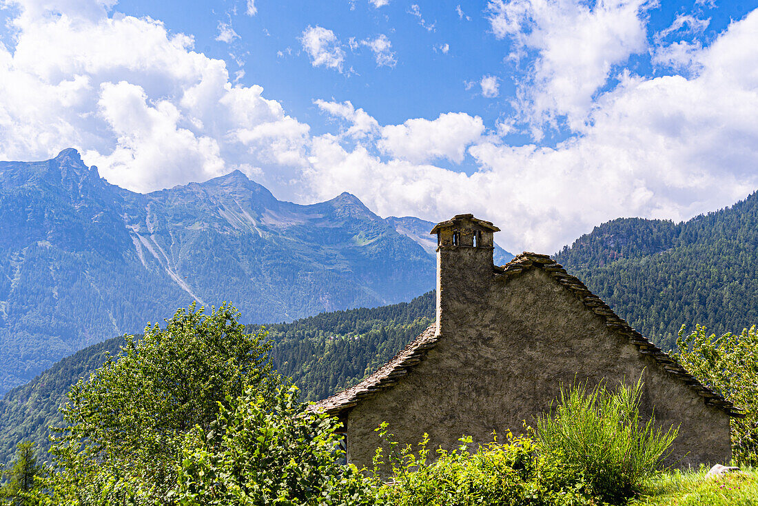 Ein traditionelles Haus im ländlichen Baustil, gebaut aus Bergfelsen in einem schönen Alpental im Sommer, Piemonte (Piemont), Norditalien, Europa